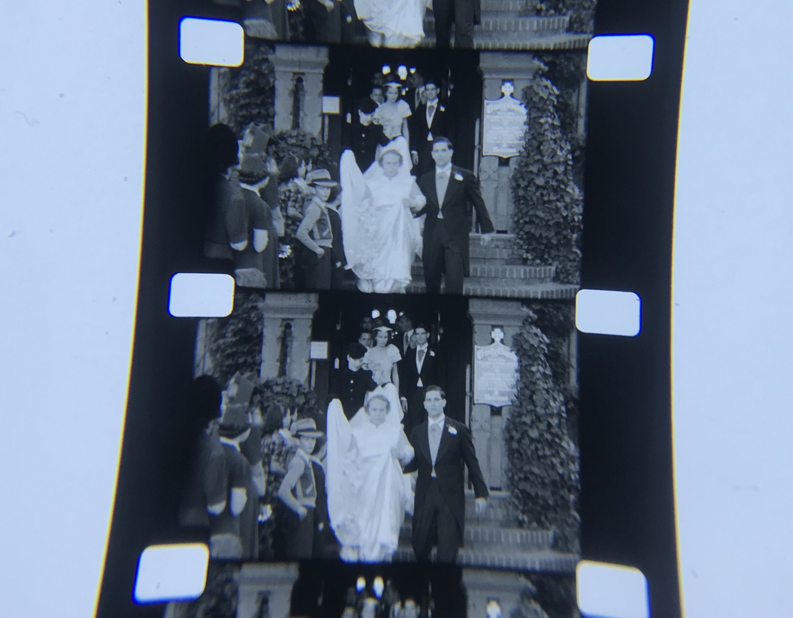 Black and white home movie of a bride and groom leaving the church. Origin of film unknown.